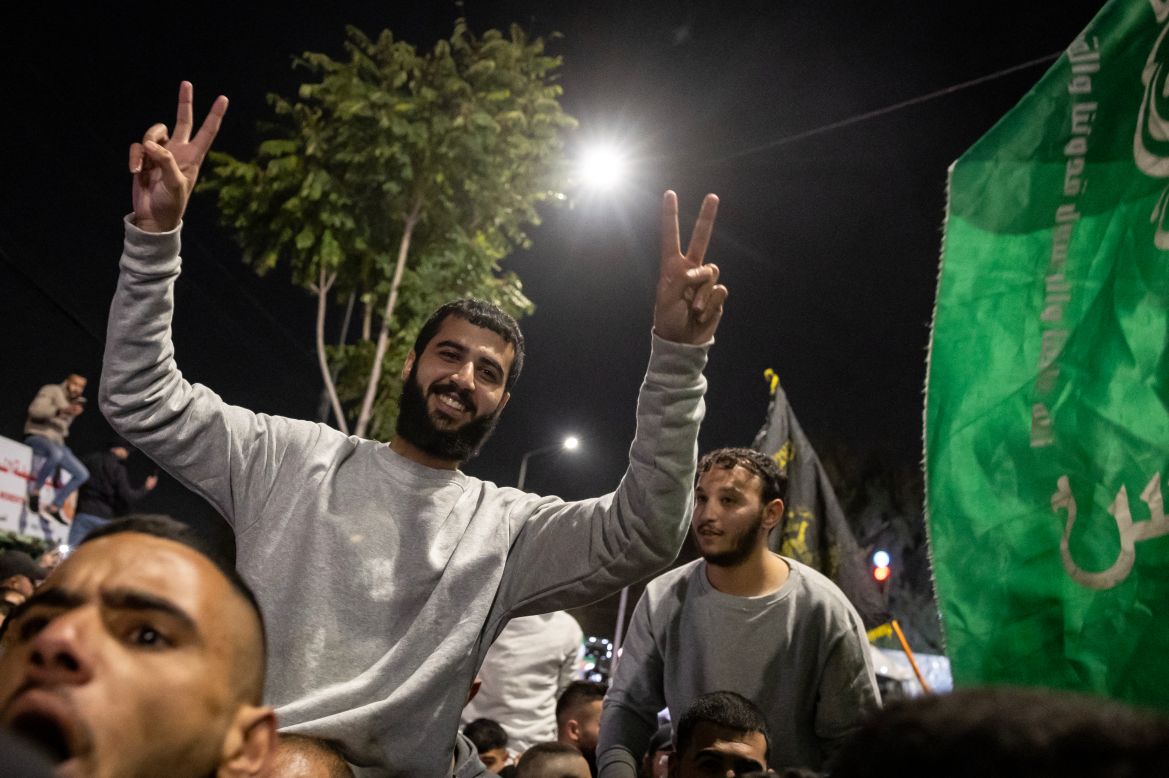 Palestinian prisoners (wearing grey jumpers) cheer among supporters and relatives after being released from Israeli jails.