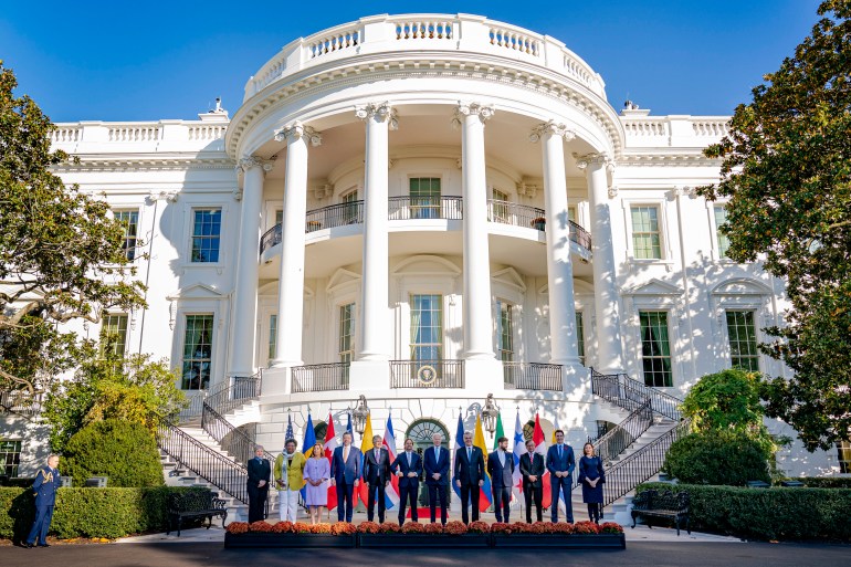 Leaders line up before the portico of the White House for a photo opportunity outdoors. 