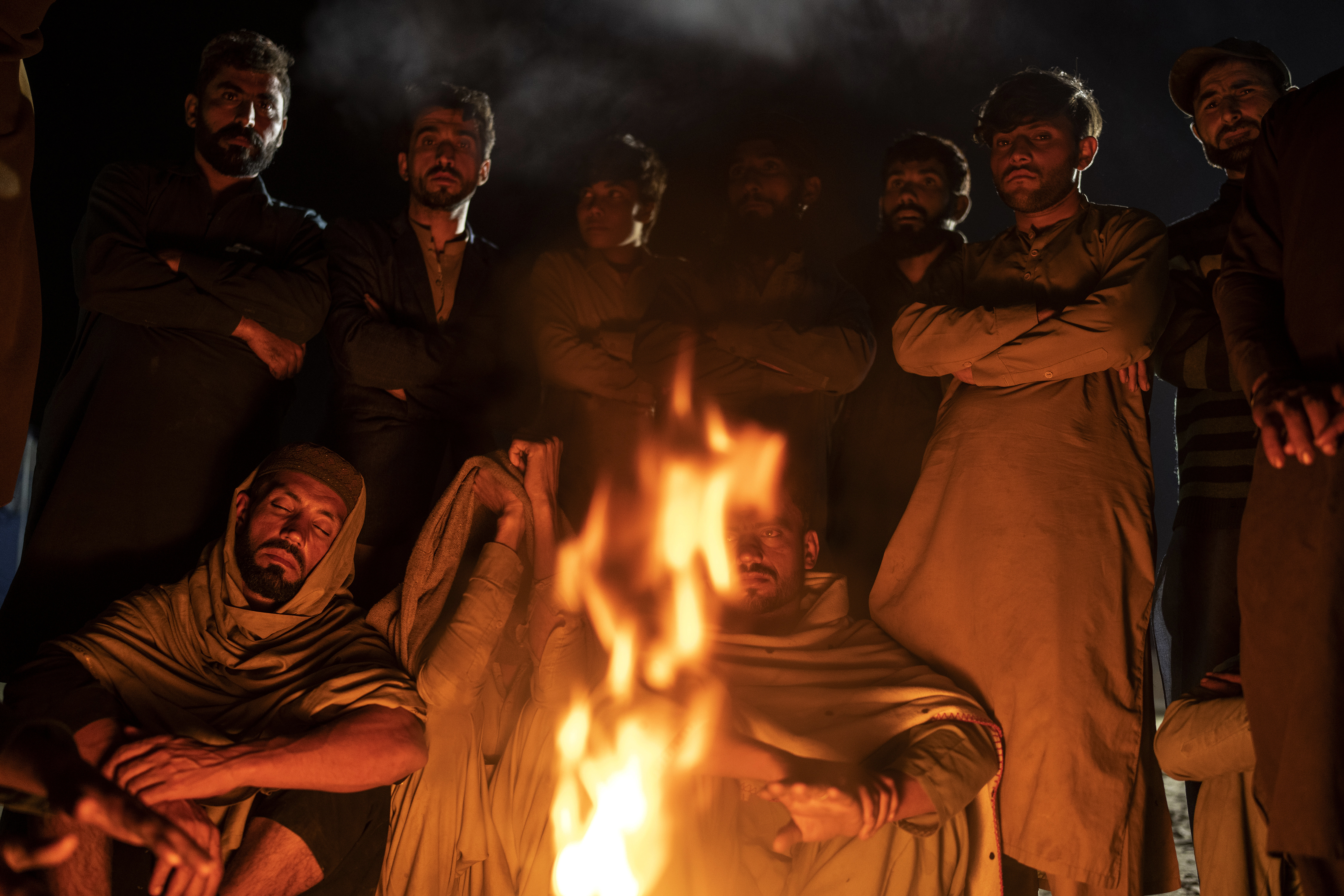 Afghan refugees warm themselves with fire in a camp near the Torkham Pakistan-Afghanistan border, in Torkham, Afghanistan.