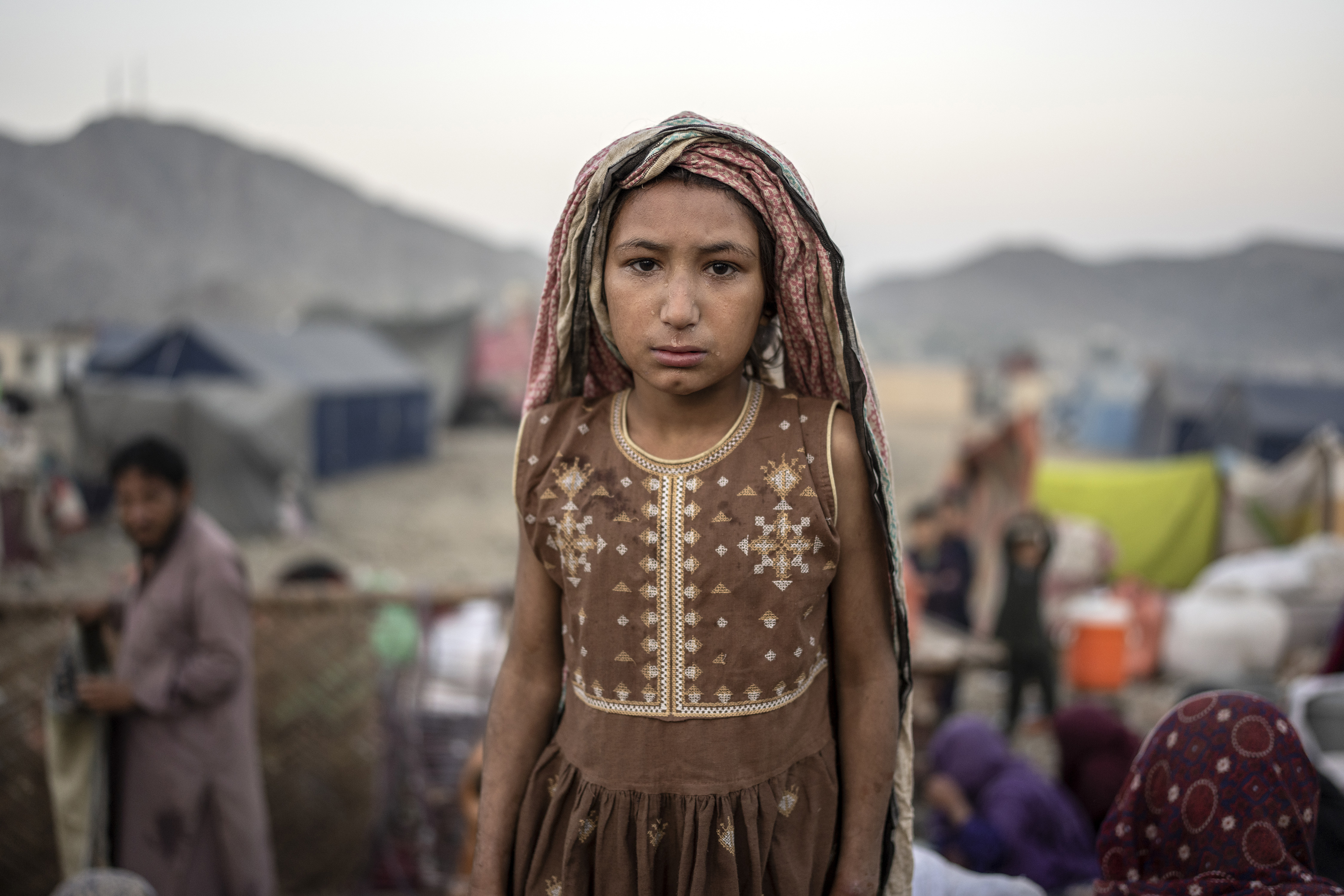An Afghan refugee girl stands for a photo in a camp near the Torkham Pakistan-Afghanistan border in Torkham, Afghanistan.