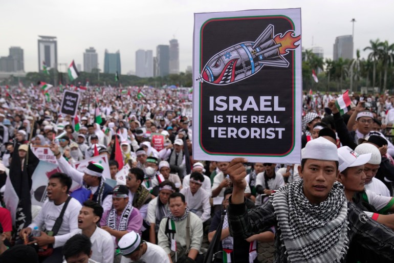 A man holds a poster during a rally in support of the Palestinians in Gaza, at the National Monument in Jakarta, Indonesia, Sunday, Nov. 5, 2023. (AP Photo/Dita Alangkara)