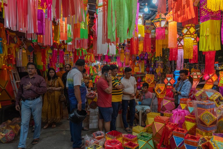 People look at lanterns displayed for sale at roadside stalls ahead of Diwali festival in Mumbai, India, 