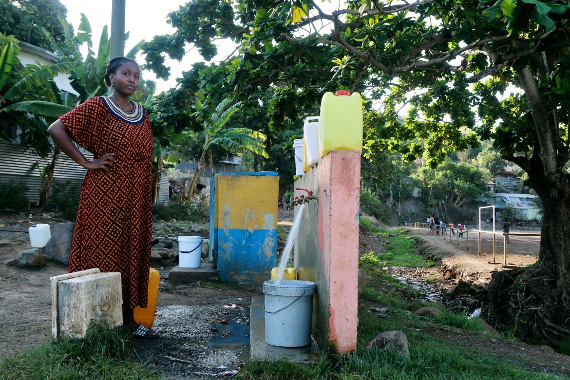 A woman waits for her bucket to be full at a water point in M'tsamoudou, near Bandrele, on the French Indian Ocean territory of Mayotte.