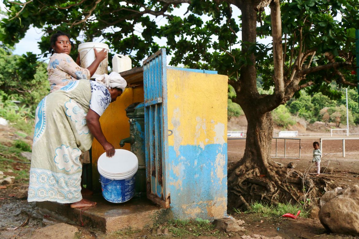 Women fill up buckets with water in the district of M'tsamoudou, near Bandrele, on the French Indian Ocean territory of Mayotte.