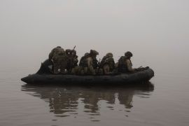 Ukrainian soldiers in an inflatable on the Dnipro river. It's foggy.