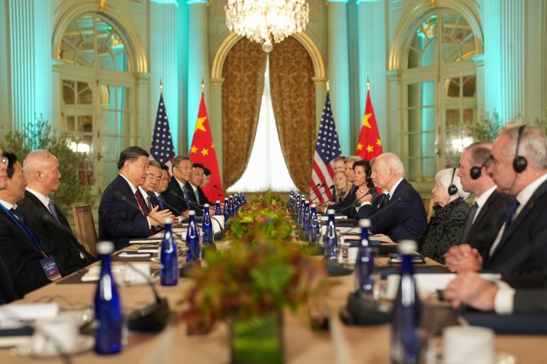 The US and Chinese delegations at their talks in California. They are facing each other across a table. Their countries' flags are at the end of the room.