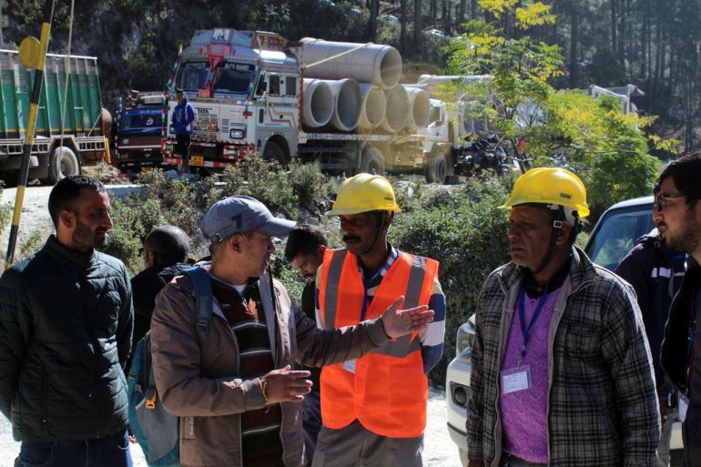 Rescue workers converse near the site of a collapsed tunnels
