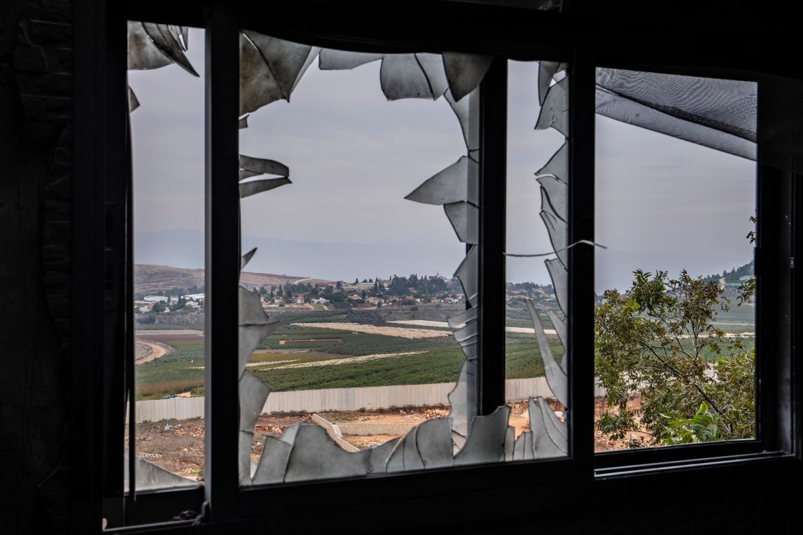 The Israeli town of Metula, background, is seen through a broken window of a house that hit by Israeli shelling in Kfar Kila border village with Israel, south Lebanon.