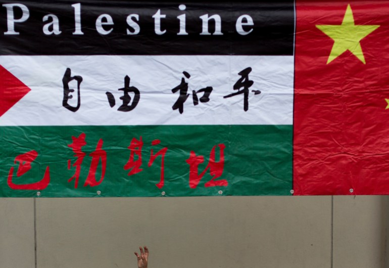 A Palestinian flag with Chinese characters for 'free and peace' written on the white middle section and a Chinese flag next to it. 