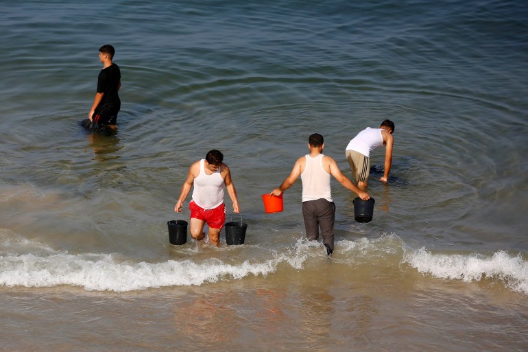 Palestinians using the sea to wash their clothes and bathe
