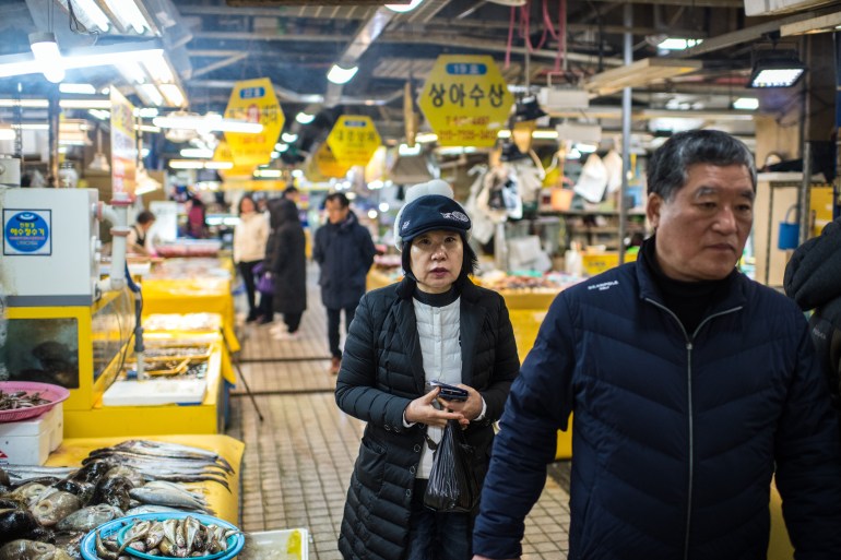 GANGNEUNG, SOUTH KOREA - FEBRUARY 15: People walk through the seafood area of Jungang Market on February 15, 2018 in Gangneung, South Korea. Open permanently since 1980 and located close to Gangneung Olympic Park, Jungang Market is one of the largest markets in the area and is popular with locals and tourists alike. 
