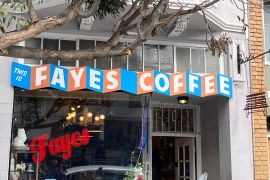 An exterior view of the San Francisco coffee shop Fayes, showing a red-and-blue sign with the café's name written in blocks.