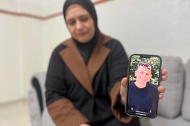 Najlaa Dmaidi holds up a picture of her son, 19-year-old Labib Dmaidi, who was killed by Israeli settlers in Huwara, Nablus, on October 6, 2023 [Zena Al Tahhan/Al Jazeera]