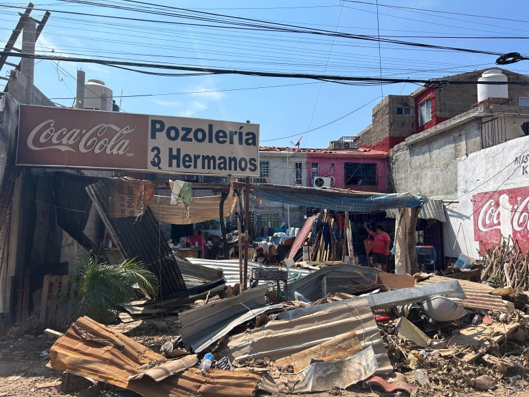 Debris sits in front of a sign that reads: "Pozoleria 3 hermanos."