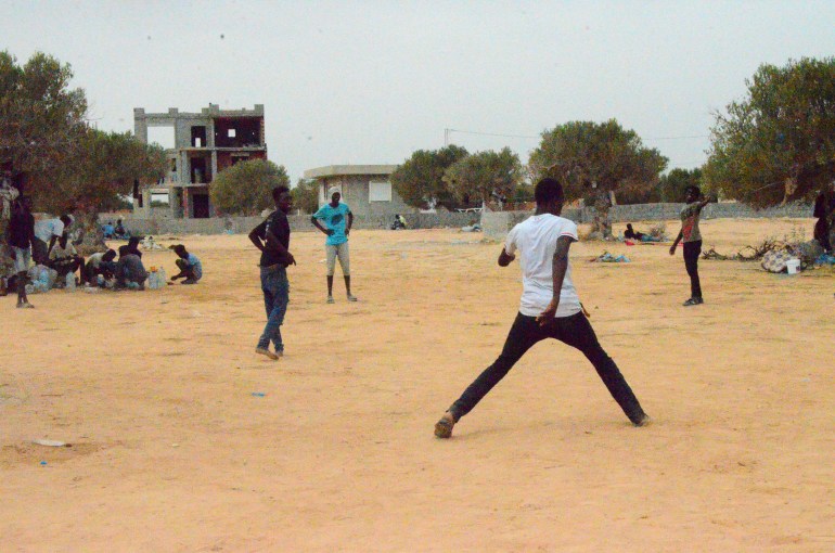 refugees playing football on a sand lot