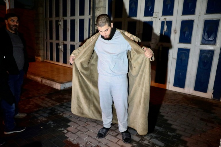 Mohammad showing his grey prison sweatsuit