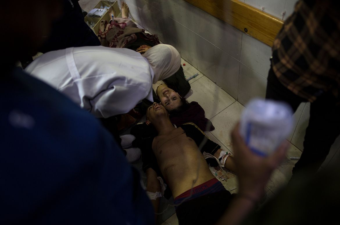 Medics provide care to wounded people lying on the floor at Nasser Hospital in Khan Yunis