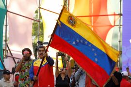 Venezuelan President Nicolas Maduro waves a Venezuelan flag, as he participates in the closing event for the campaign