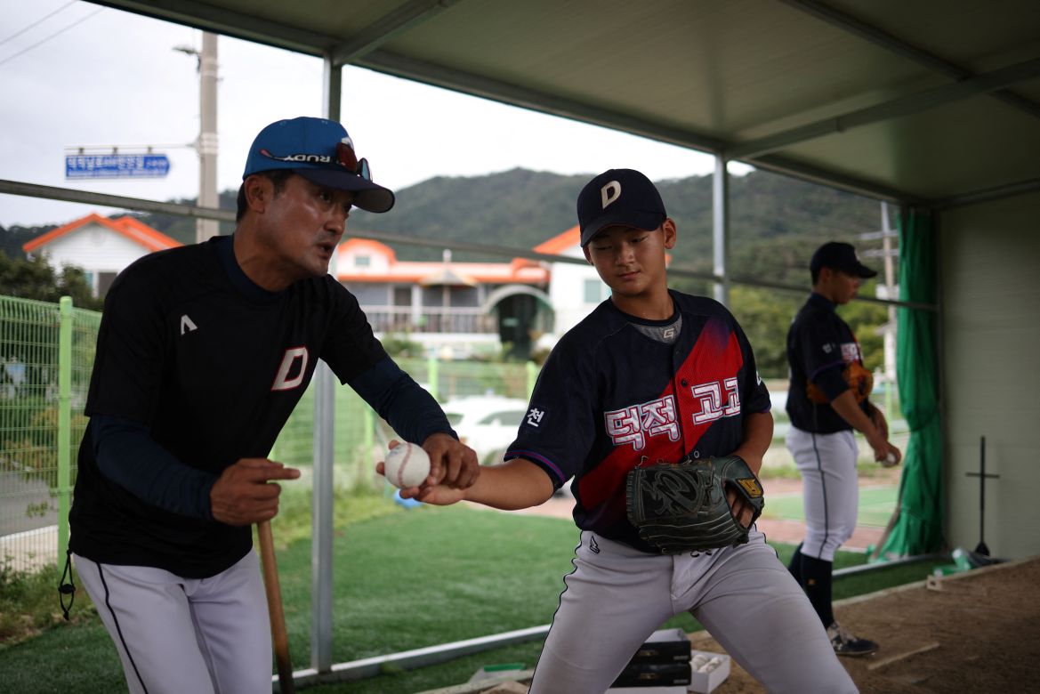 Jang Sung-jin, pitching coach of the Deokjeok High School baseball team, gives feedback to An Seung-han, 17, during a practice session, on Deokjeok island in Incheon, South Korea.