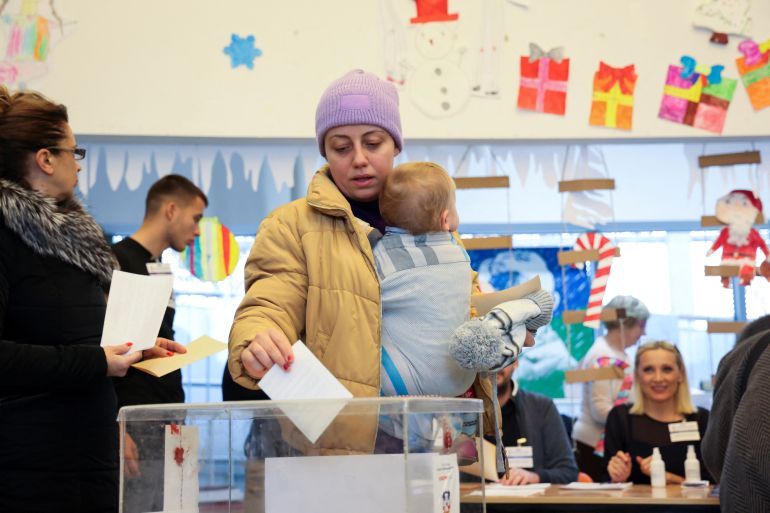 A woman casts her vote at a polling station during the parliamentary election in Belgrade