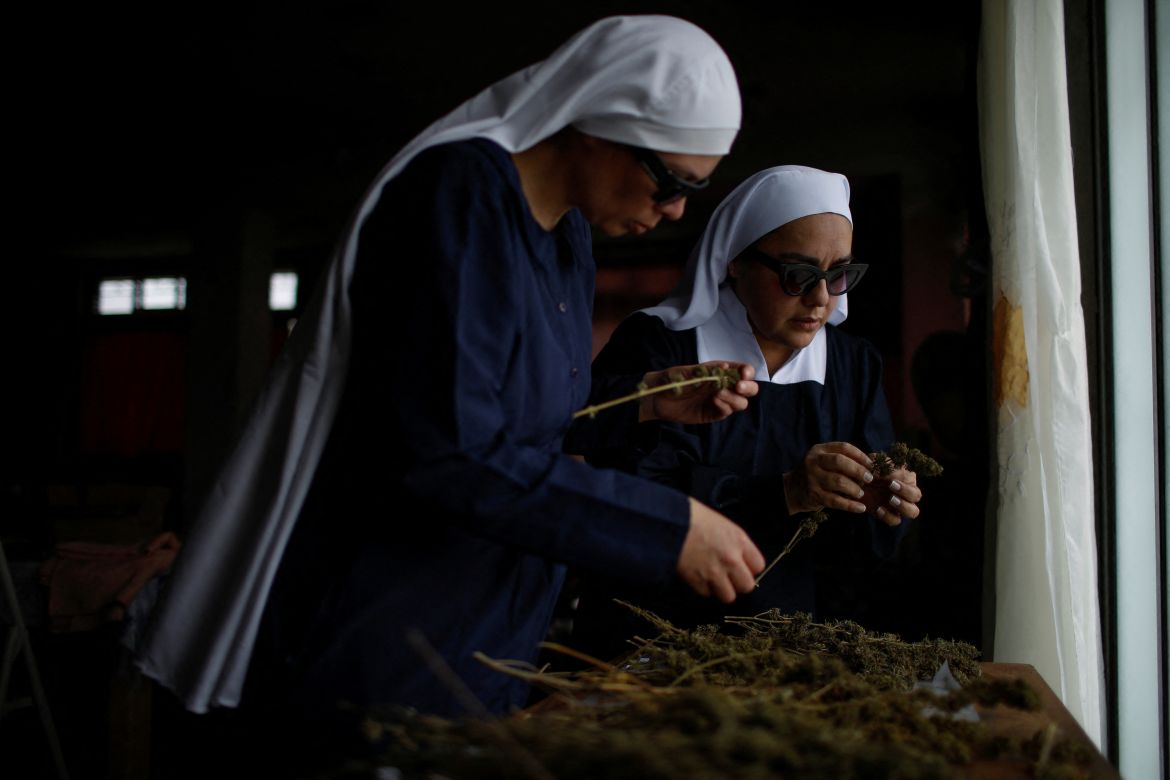 Members of Sisters of the Valley, a non-religious international group founded in 2014 which has pledged to spread the gospel of the healing powers of cannabis, who use the monikers "Sister Kika" and "Sister Bernardet" online and asked not to give their names for fear of reprisal, check hemp that is drying at a house on the Sisters of the Valley's farm on the outskirts of a village in central Mexico, September 2, 2023.