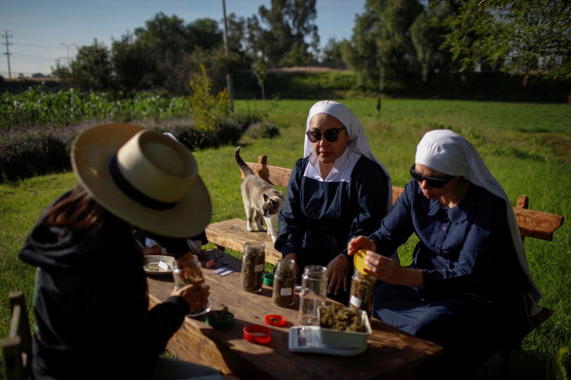 Members of Sisters of the Valley, a non-religious international group founded in 2014 which has pledged to spread the gospel of the healing powers of cannabis, who use the monikers "Sister Kika" and "Sister Bernardet" online and asked not to give their names for fear of reprisal, and Alehli Paz (L), 34, a chemist and marijuana researcher working with the group, weigh and store hemp at the Sisters of the Valley's farm on the outskirts of a village in central Mexico, September 3, 2023.