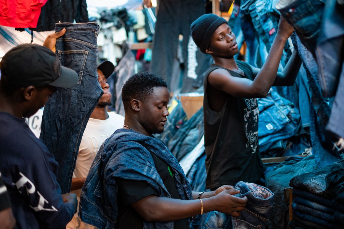 Vendors display second-hand clothes while waiting for costumers at a market in Kampala.