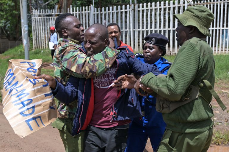 Kenyan police officers arrest a member of the Communist party of Kenya