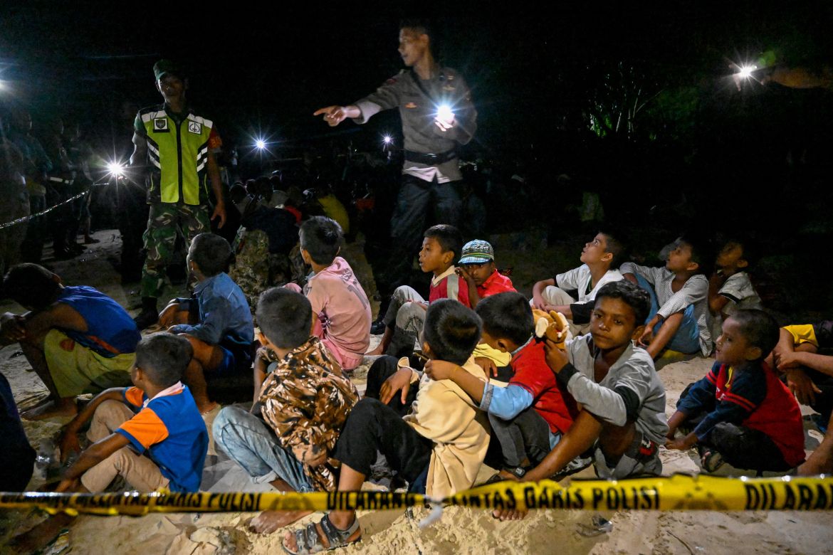 Police inspect Rohingya refugees at a beach on Sabang island, Aceh province on December 2
