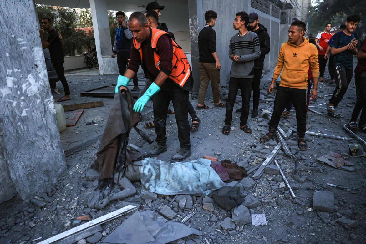 A rescuer covers the body of a children killed in an Israeli strike in Rafah in the southern Gaza Strip.