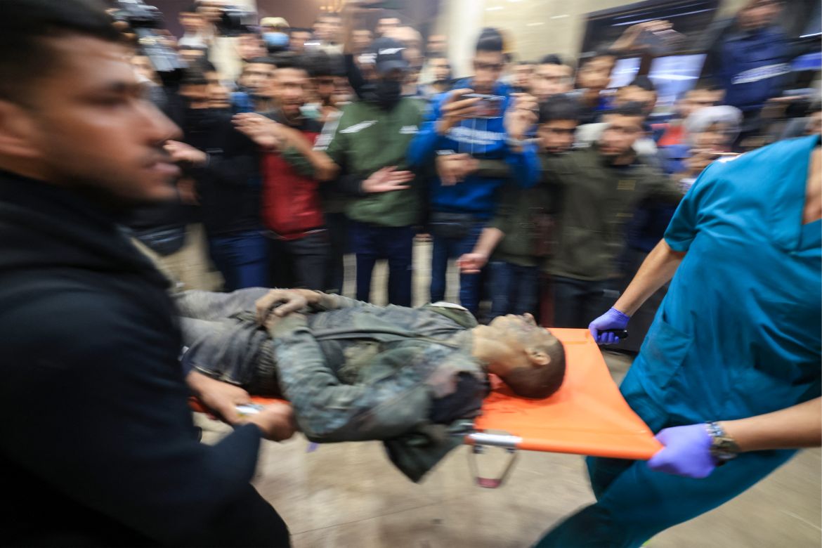 Graphic content / A Palestinian man, wounded during Israeli bombardment, is stretchered into Nasser hospital in Khan Yunis in the southern Gaza Strip on December 4