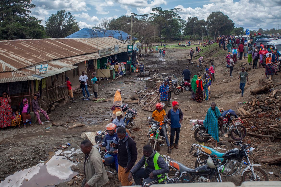 People gather to assess damages at a street covered on mud following landslides and flooding triggered by heavy rainfall in Katesh, Tanzania.