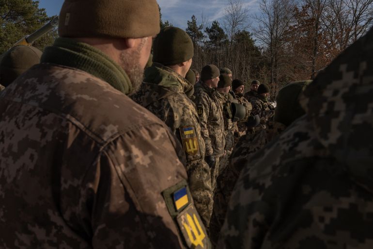Ukrainian soldiers during training. They are standing in a line looking away.