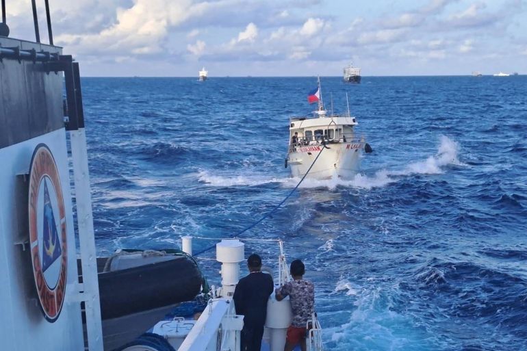 This handout photo taken and released on December 10, 2023 by the Philippine Coast Guard (PCG) shows the M/L Kalayaan chartered supply boat (R) being towed after a Chinese coast guard ship unleashed water cannon onto the vessel, during a mission to deliver provisions at Second Thomas Shoal in disputed waters of the South China Sea. - A Philippine boat was "rammed" by a Chinese coast guard ship during a resupply mission on December 10, the Philippine coast guard said, in the latest such confrontation in the disputed South China Sea. The Philippine Coast Guard also said a Chinese ship "water cannoned" three Philippine vessels involved in the resupply mission, causing "serious engine damage" to one of the boats. (Photo by Handout / Philippine Coast Guard (PCG) / AFP) / RESTRICTED TO EDITORIAL USE - MANDATORY CREDIT "AFP PHOTO / PHILIPPINE COAST GUARD (PCG)" - NO MARKETING - NO ADVERTISING CAMPAIGNS - DISTRIBUTED AS A SERVICE TO CLIENTS - RESTRICTED TO EDITORIAL USE - MANDATORY CREDIT "AFP PHOTO / PHILIPPINE COAST GUARD (PCG)" - NO MARKETING - NO ADVERTISING CAMPAIGNS - DISTRIBUTED AS A SERVICE TO CLIENTS /