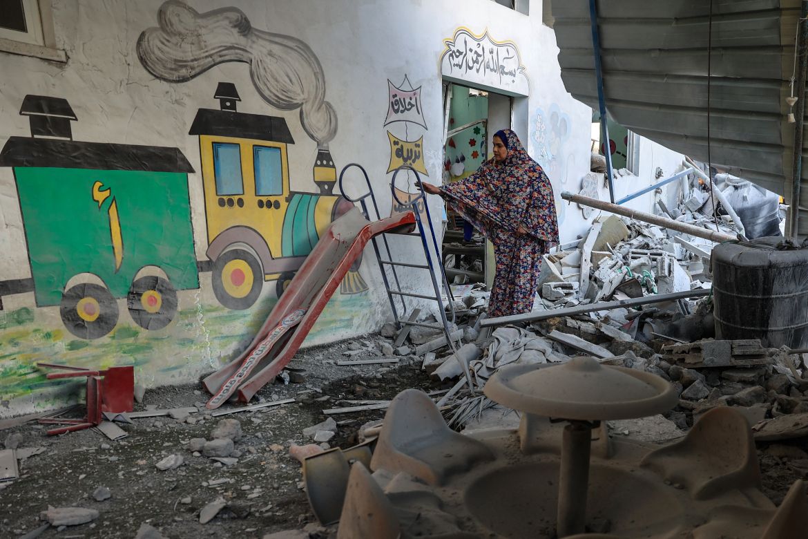 A woman and stands amid the rubble at a kindergarten hit by Israeli bombing in Rafah in the southern Gaza Strip.