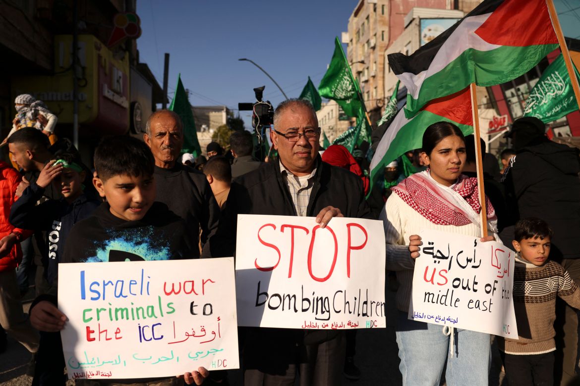 Palestinian protestors hold signs during a rally supporting the Gaza Strip amid ongoing battles between Israel and the Palestinian movement Hamas, on December 11