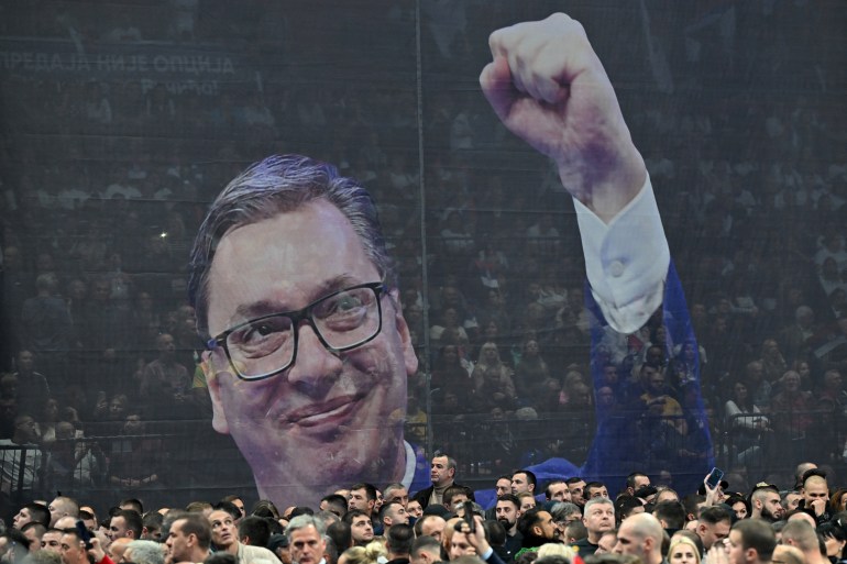Supporters of the Serbian Progressive Party gather in front of a giant banner bearing a image of Serbian President Aleksandar Vucic during a political rally of the Serbian Progressive Party (SNS) at the Stark Arena in Belgrade on December 2, 2023,. - Along with parliamentary elections on December 17, Serbian citizens will cast ballots, in 65 municipalities, including the capital Belgrade.