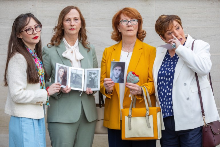 Rita Bonner (2R) and family members pose with pictures of her brother, John Laverty as they arrive for the verdict into the Ballymurphy inquest at Waterfront Hall in Belfast on May 11, 2021. The findings of an inquest into the deaths of 10 people by British soldiers in the Ballymurphy area of Belfast in 1971 are due to be published today. (Photo by PAUL FAITH / AFP)
