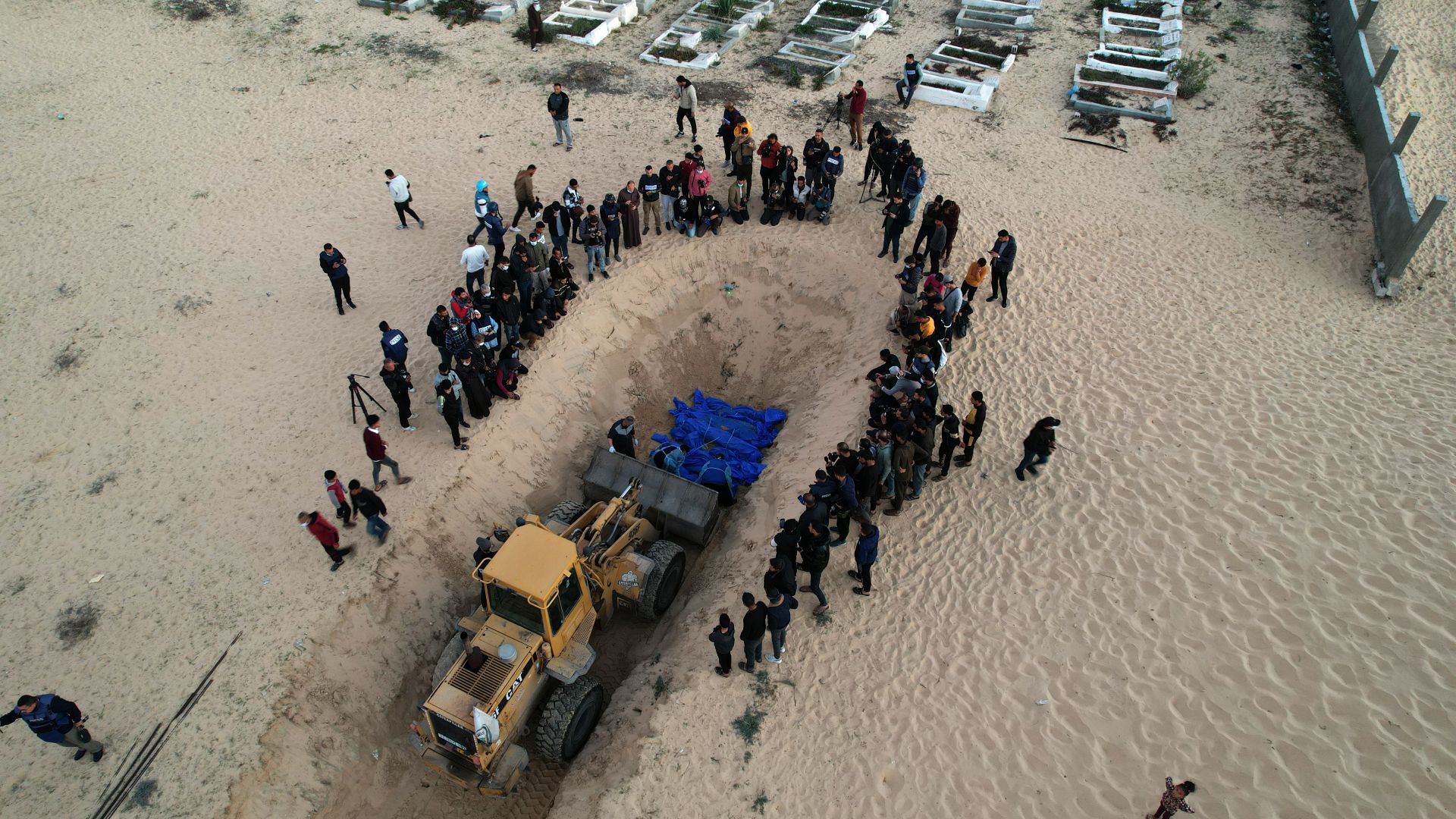 An aerial view of burial of the 80 Palestinians who died in Israeli attacks, to a mass grave at Tel al-Sultan Cemetery in Rafah, Gaza on December 26
