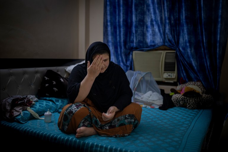 Refugee and former Afghan policewoman Khatera Hashmi sits inside a rented accommodation in New Delhi, India on Aug. 13, 2021. When the Taliban shot policewoman Khatira Hashmi and gouged out her eyes, she knew Afghanistan was no longer safe. Along with her husband, she fled to India last year. She was shot multiple times on her way home from work last October in the capital of Ghazni province, south of Kabul. As she slumped over, one of the attackers grabbed her by the hair, pulled a knife and gouged out her eyes. (AP Photo/Altaf Qadri)