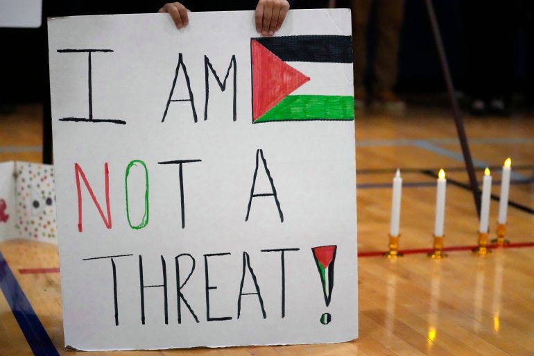 Easton Amjad Waz, 5, holds a sign during a vigil for Wadea Al Fayoume at Prairie Activity and Recreation center in Plainfield, Ill., Tuesday, Oct. 17, 2023. An Illinois landlord accused of fatally stabbing the 6-year-old Muslim boy and seriously wounding his mother was charged with a hate crime after police and relatives said he singled out the victims because of their faith and as a response to the war between Israel and Hamas. (AP Photo/Nam Y. Huh)