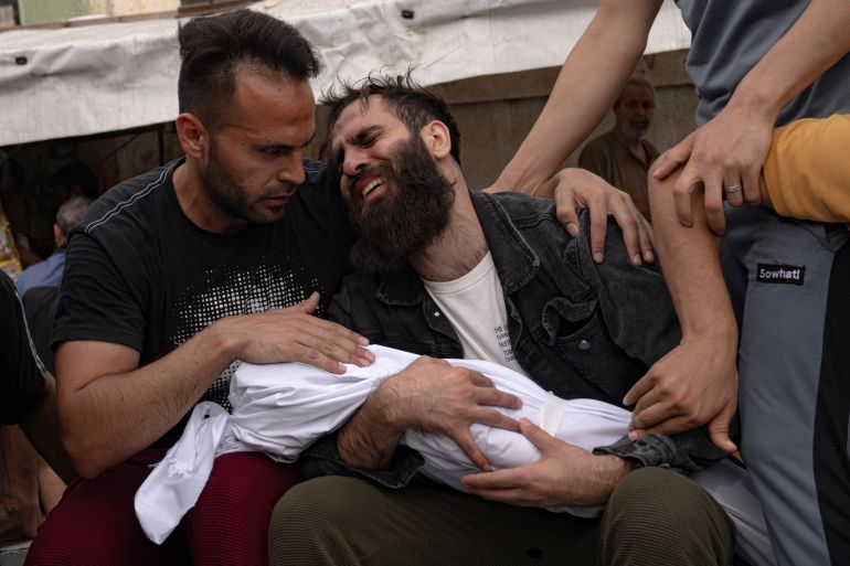 Palestinians mourn their relatives killed in the Israeli bombardment