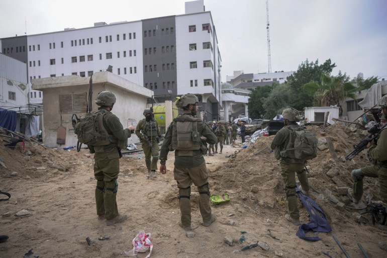 Israeli soldiers stand outside Shifa Hospital in Gaza City