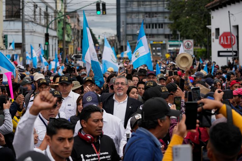Arevalo stands in a sea of supporters on the streets of Guatemala City, some waving Guatemalan flags.