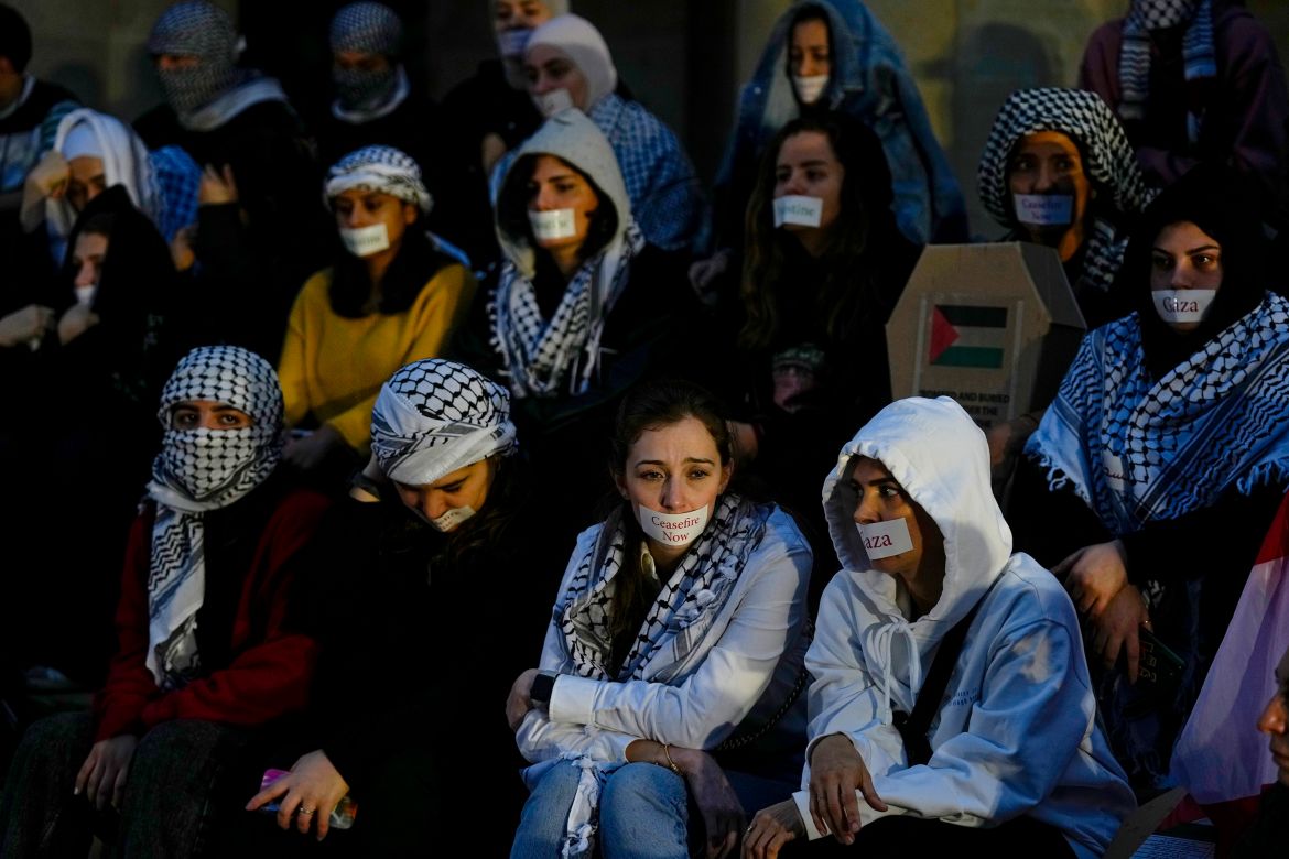 Demonstrators put stickers on their mouths during a protest calling for an end to the war in Gaza and for an immediate cease-fire, in front of the Lebanese National Museum in Beirut, Lebanon, Friday, Dec. 8