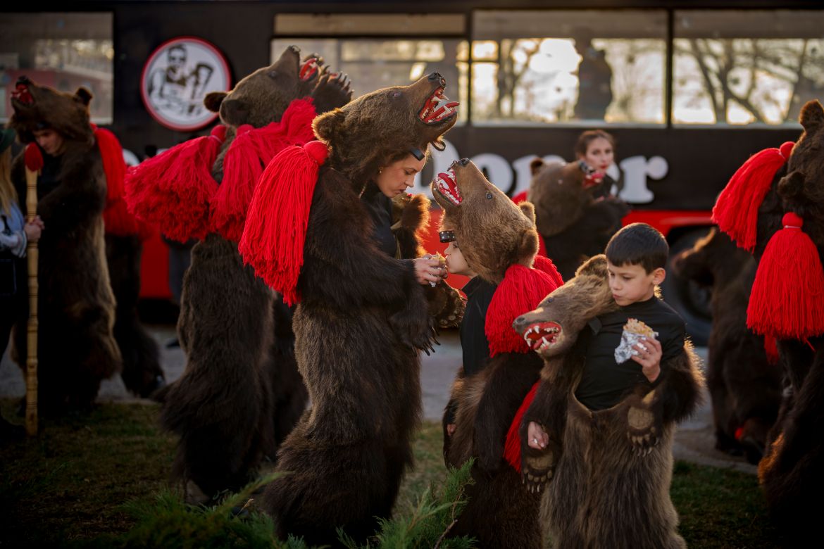 Members of a traditional bear pack enjoy a snack before performing in a festival in Moinesti, northern Romania, Wednesday, Dec. 27,