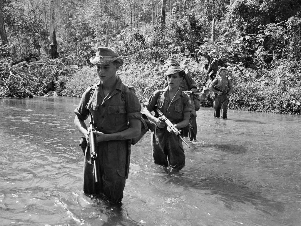 British Troops ford a stream during a jungle patrol at Kajang shortly after the war against Communist terrorists was resumed on Feb.15,1956. (AP Photo/Fred Waters)