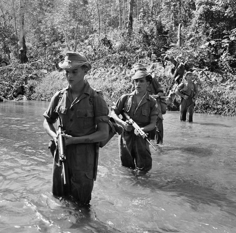 British Troops ford a stream during a jungle patrol at Kajang shortly after the war against Communist terrorists was resumed on Feb.15,1956. (AP Photo/Fred Waters)
