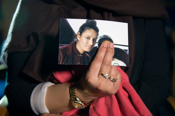 a person holds a photograph of a teenage girl - with her fingers covering the person next to her in the photo