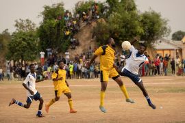 Football players on a field in a refugee camp in Zambia